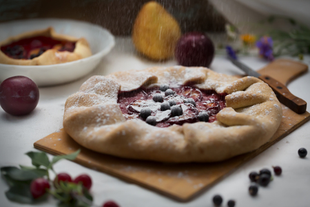 Traditional rustic cake prepared from dough and plum powdered with sugar powderの写真素材