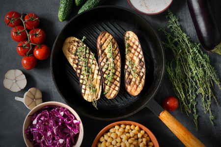 Grilled eggplants with thyme on the grill with other vegetablesの写真素材