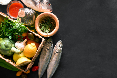 Mediterranean fish - dorado and vegetables on the chalkboard. top viewの写真素材