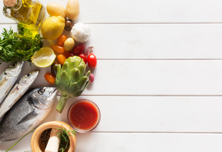 Fresh organic food - natural sea fish and veggies on the wooden surfaceの写真素材
