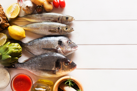 Fresh organic food - natural sea fish and veggies on the wooden surfaceの写真素材