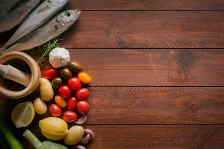Fresh organic food - natural sea fish and veggies on the wooden surfaceの写真素材