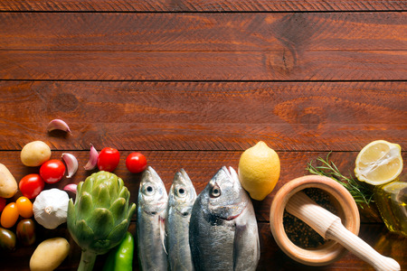 Fresh organic food - natural sea fish and veggies on the wooden surfaceの写真素材