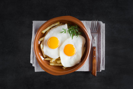 Traditional spanish lunch - fried eggs with french fries, cured pork slices jamonの写真素材