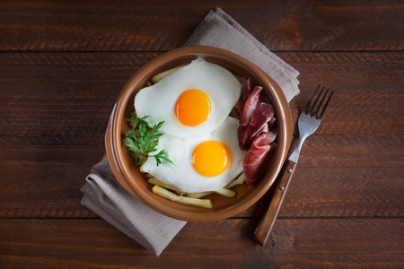 Traditional spanish lunch - fried eggs with french fries, cured pork slices jamonの写真素材