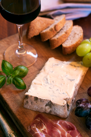 Piece of Spanish Blue cheese on an old wooden cutting board, selective focus. Close upの写真素材