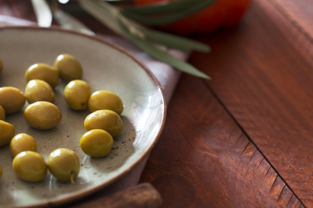 Fresh green olives on the rustic plateの写真素材
