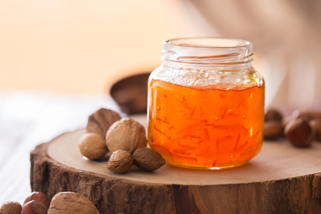 Peach jam in a transparent jar on the dark tableの写真素材