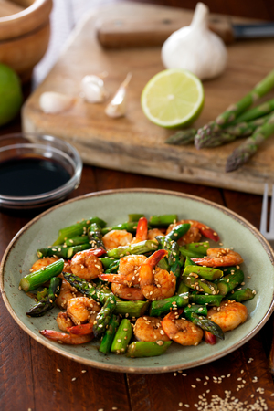 Salad with asparagus and shrimps in plate. Ingredients on the tableの写真素材