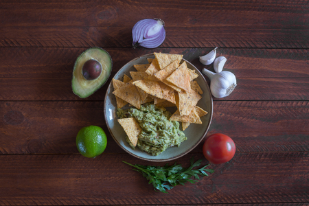 Plate of guacamole with tortilla chips and ingredientsの写真素材