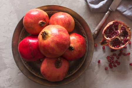 Ripe pomegranate on a metallic plate on a dark background. Top viewの写真素材