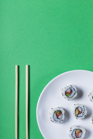 Japanese sushi on a green background. Rolls and sticks for traditional asian food. Top view with copy spaceの写真素材