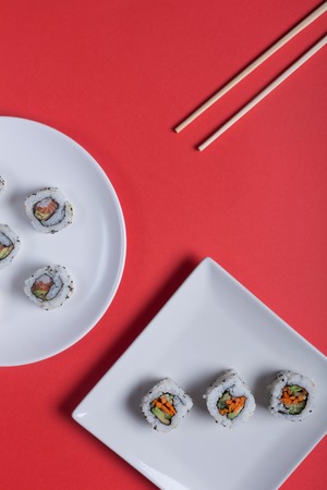 Japanese sushi on a red background. Rolls and sticks for traditional asian food. Top viewの写真素材