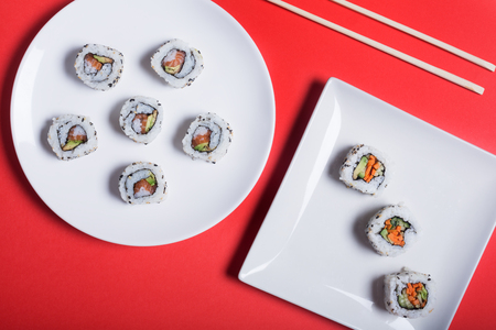 Japanese sushi on a red background. Rolls and chopsticks for traditional asian food. Top viewの写真素材