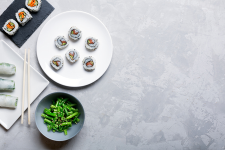 Traditional japanese and chinese food. Steamed green beans and sushi rollsの写真素材
