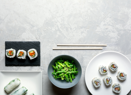 Traditional japanese and chinese food. Steamed green beans and sushi rollsの写真素材