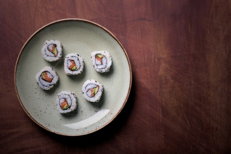 Traditional japanese and chinese food. Sushi rolls on a brown wooden tableの写真素材
