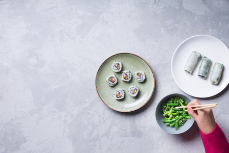 Woman takes the sushi rolls using chopsticks. Top view with copy spaceの写真素材