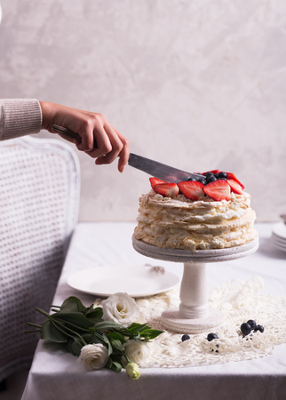 Strawberry pavlova cake decorated by womanの写真素材