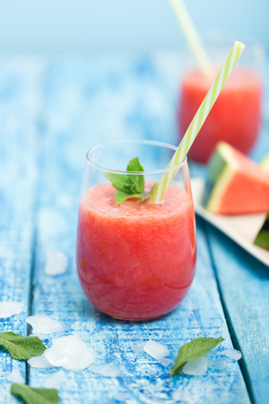 Fresh watermelon smoothie in two glasses on a blue wooden rustic backgroundの写真素材