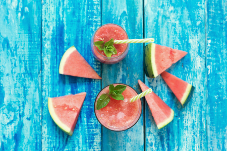 Fresh watermelon deink in two glasses on a blue wooden rustic background, topviewの写真素材