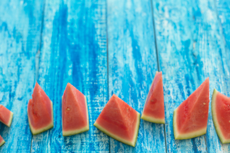 Watermelon pieces on a blue wooden rustic background with a copy spaceの写真素材