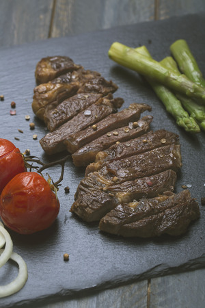 Grilled beef steak with vegetables on a black backgroundの写真素材