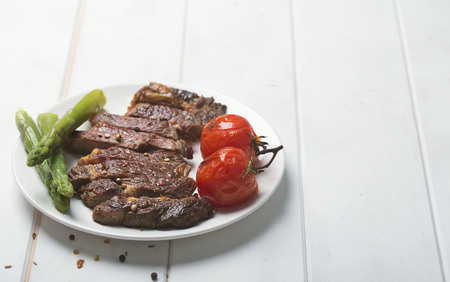 Grilled beef steak on a white plate and white backgroundの写真素材