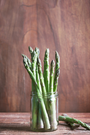 Banches of fresh green asparagus on wooden background. Rustic styleの写真素材
