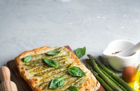 Asparagus green pizza with herbs and mozzarella on the concrete rustic backgroundの写真素材