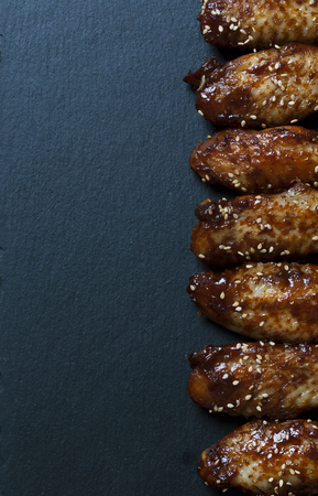 Traditional Asian wings on the black background. Top view with copy spaceの写真素材