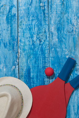 Equipment for playing beach tennis on the blue wooden background. Vertical orientation conceptの写真素材