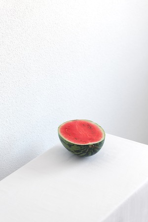 Half of watermelon on a white table with copy spaceの写真素材