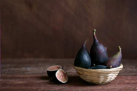 Whole figs and one fig sliced in half on the table. Organic food for healthy lifeの写真素材
