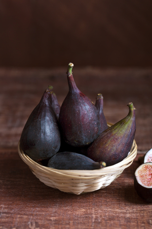 Whole figs and one fig sliced in half on the table. Organic food for healthy lifeの写真素材