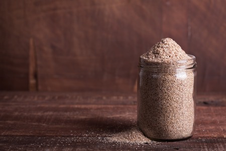Dry bran in a glass jar on a wooden surfaceの写真素材