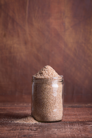Dry bran in a glass jar on a wooden surfaceの写真素材