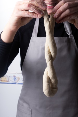 Woman on the home kitchen prepares the dough with flour to make organic pan, bread or pasta