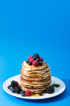 Pancakes with berries on the pale and honeyの写真素材