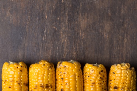 Grilled corn cobs on the brown rusticの写真素材