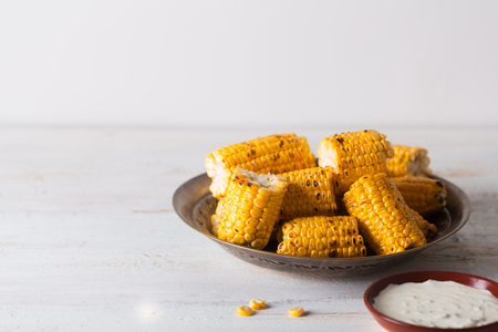 Grilled corn cobs on the old vintage plate with copy space.の写真素材