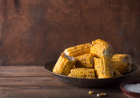 Grilled corn cobs on the brown rusticの写真素材