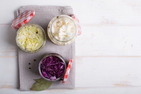 Sauerkraut in jars on a wooden table. Copy spaceの写真素材