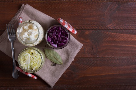 Sauerkraut in a blue bowl on a wooden table. Top viewの写真素材