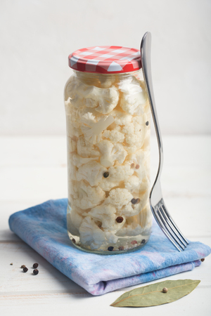 Fermented cauliflower in a jar on a wooden tableの写真素材