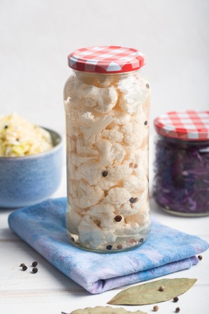 Fermented cauliflower in a jar on a wooden tableの写真素材