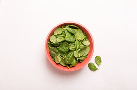 Washed fresh mini spinach in a bowl on the tableの写真素材
