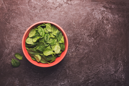 Washed fresh mini spinach in a bowl on the table. Copy spaceの写真素材