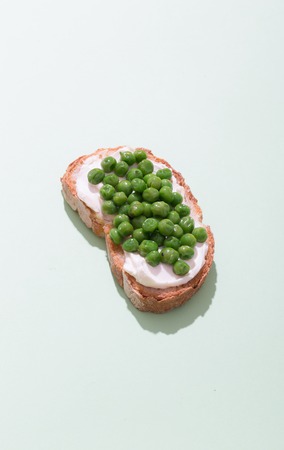 Green pea sandwich prepared with creamy cheese and bread on the green backgroundの写真素材