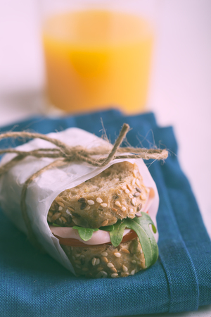 Homemade sandwiches with ham, tomatoes and fresh vegetables salad sprinkled with olive oil. Food on the white stylish plateの写真素材